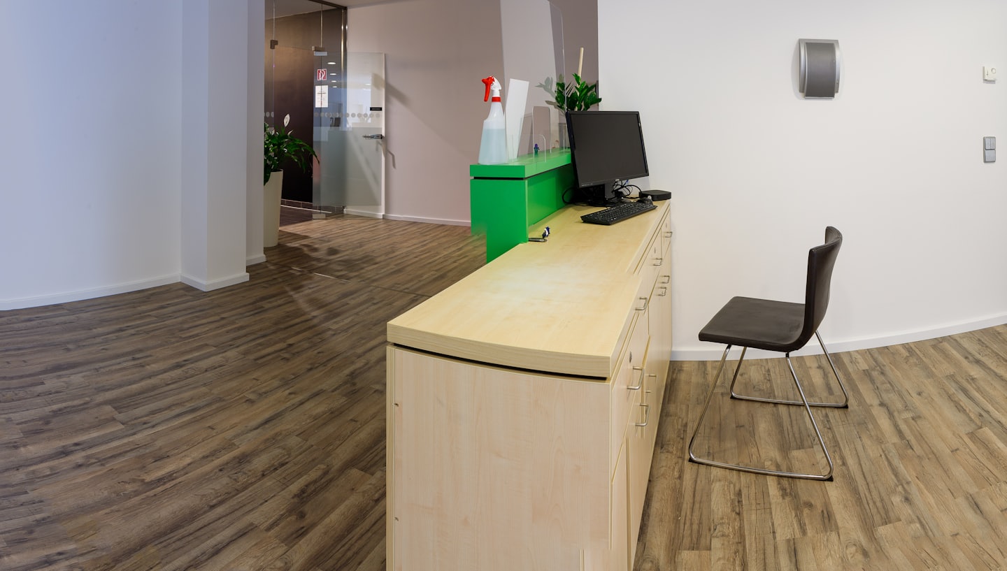 Modern office reception desk with a computer and protective dividers.