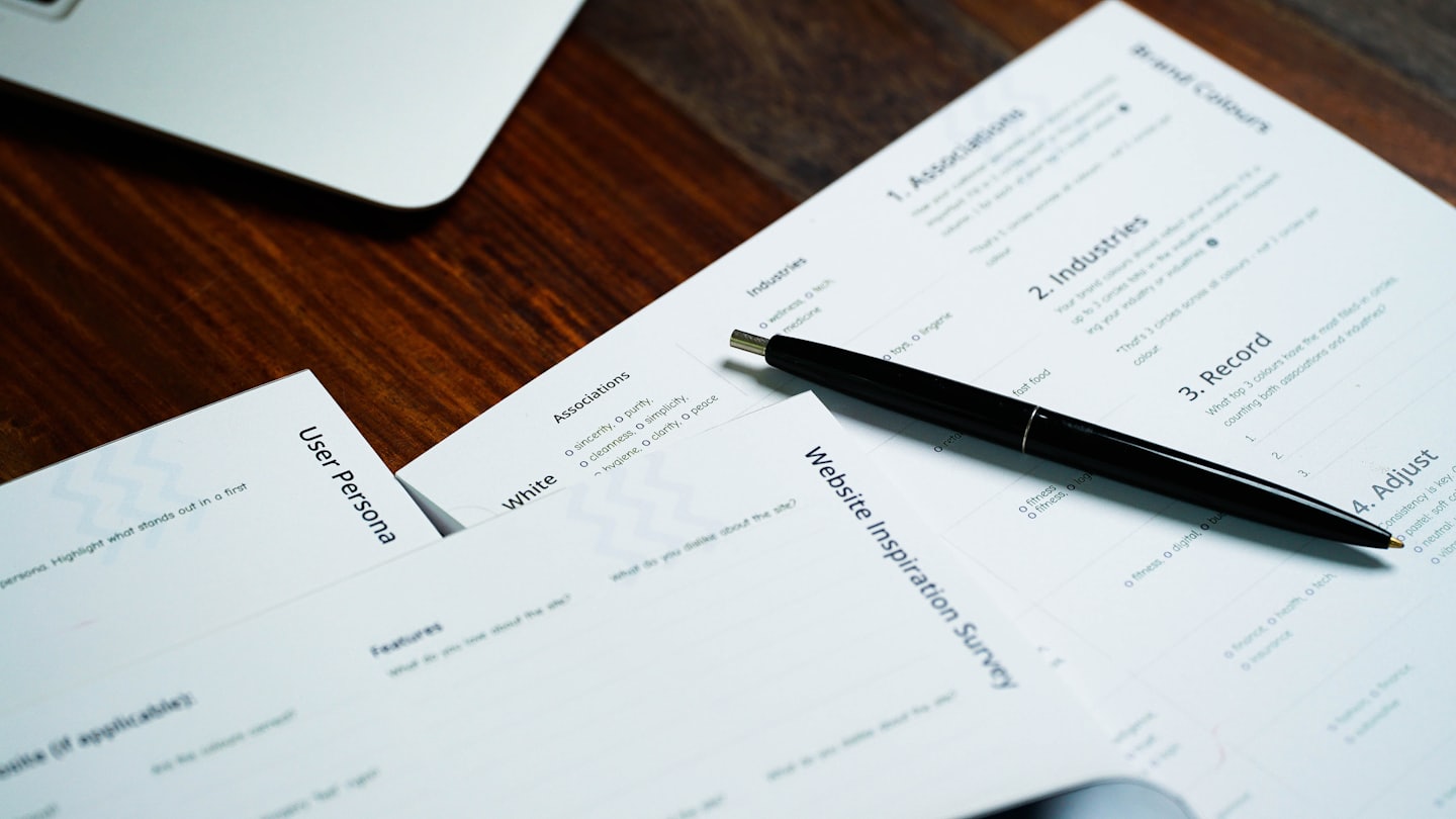 Business documents and laptop on a wooden desk.